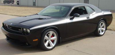 black dodge challenger in a sunny parking lot with a white decal arcing down the side of it